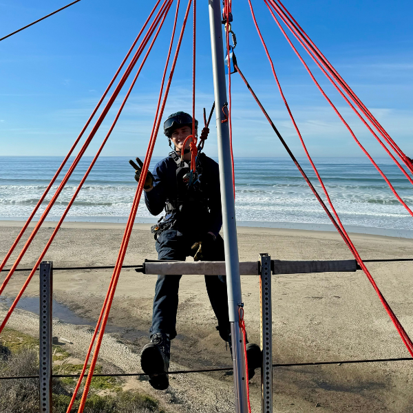 Technical Rescue Techncian harnessed up with ropes to practice a rescue drill with the ocean in the 